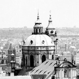 Baroque church dome over historic city rooftops.