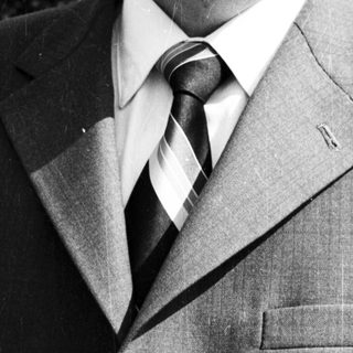 Portrait of a man in formal attire outdoors.