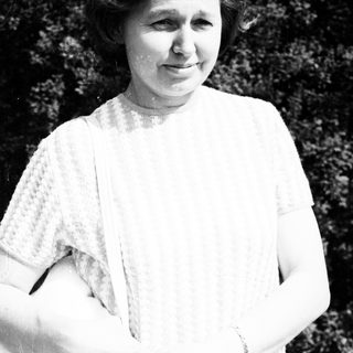 Woman in vintage clothing posing outdoors.