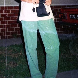 Person holding vintage camera outdoors at night.
