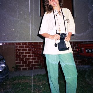 Person holding vintage camera outdoors at night.