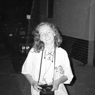 Person wearing white outfit holding trophy.