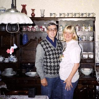 Two people standing in a vintage kitchen with retro decor.