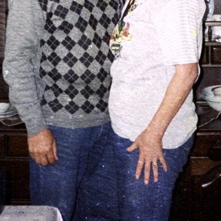 Two people standing in a vintage kitchen with retro decor.