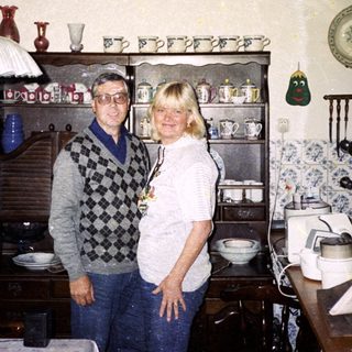 Two people standing in a vintage kitchen with retro decor.
