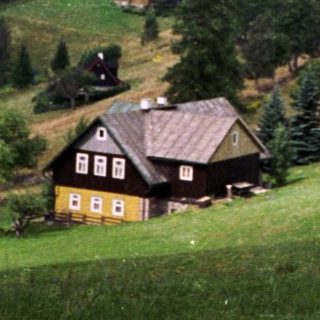 Rural countryside with rolling hills, forests, and farmhouses.