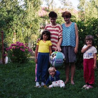 Family photo outdoors with four children and two adults.