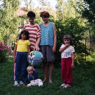 Family photo outdoors with four children and two adults.