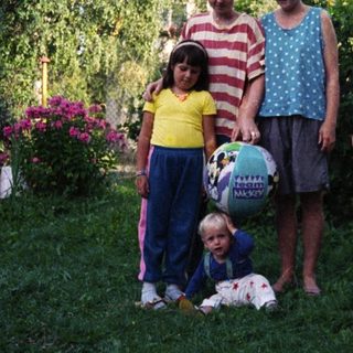 Family photo outdoors with four children and two adults.
