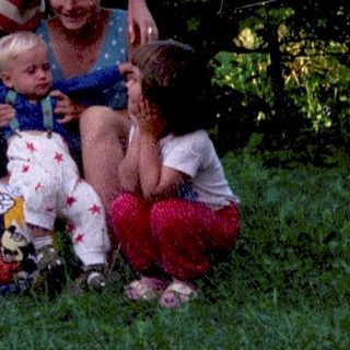 Family posing outdoors with children and dog.
