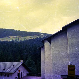 Mountainous landscape with forest and buildings.