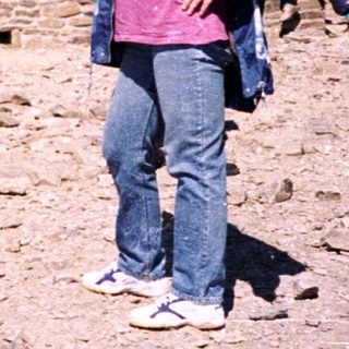 Two people hiking near a stone tower.