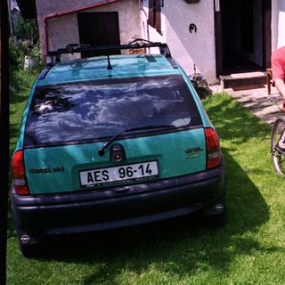 Man on bike near parked car.