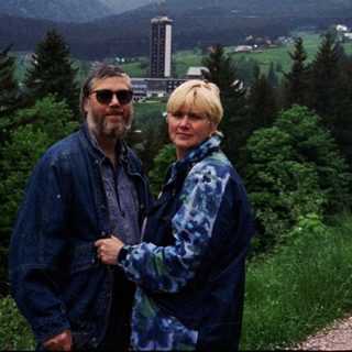 Two people standing on a scenic mountain road.