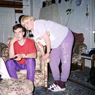 Two people indoors, one leaning on cane.