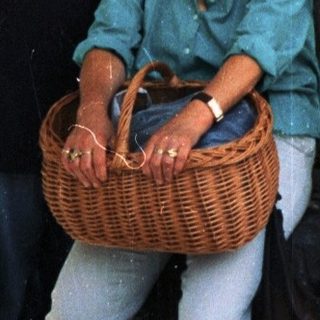 Two people posing together under an arched doorway holding a basket.