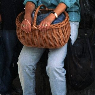 Two people posing together under an arched doorway holding a basket.