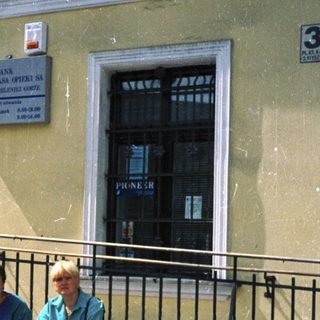 Two people sitting outside Bank Polska Kasprowicz.