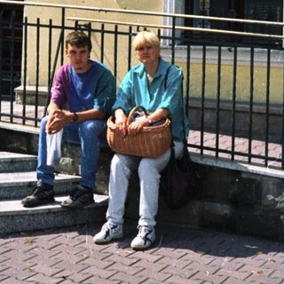 Two people sitting outside Bank Polska Kasprowicz.