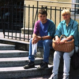 Two people sitting outside Bank Polska Kasprowicz.