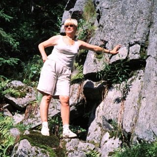 Woman posing confidently on rocky trail.
