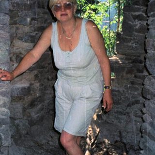 Woman standing in a stone archway.