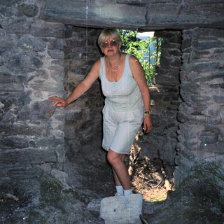 Woman standing in a stone archway.