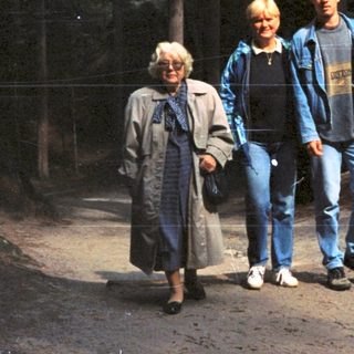 Three people walking together in a forested area.