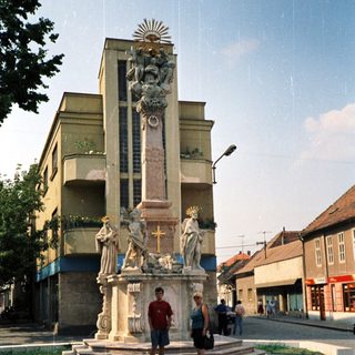 Baroque-style monument with statues in urban plaza.