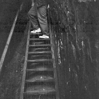 Person taking photo on wet stairs.
