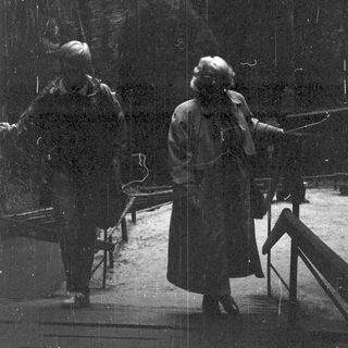 Two people walking in rainforest under heavy rain.
