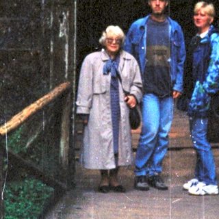 Three people standing on a wooden bridge inside a cave.