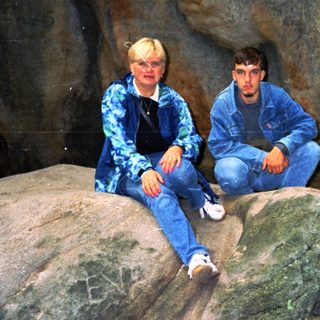 Two people sitting on rocks in a cave.