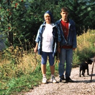Three people hiking on scenic mountain trail.