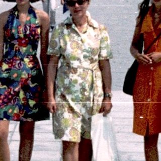 Three women walking in a large urban square.
