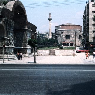 Ancient ruins in urban setting with modern buildings.