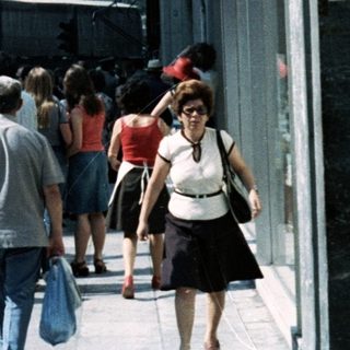 Busy urban street scene in Athens with Acropolis in background.