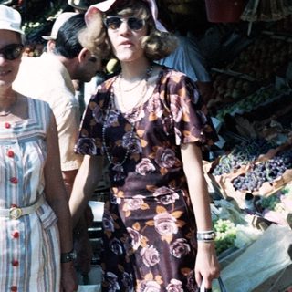 Two women posing at an outdoor market.