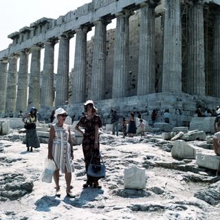 Ancient Greek temple ruins with visitors.