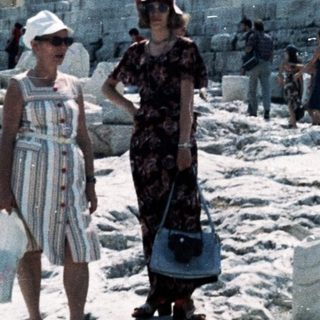 Ancient Greek temple ruins with visitors.