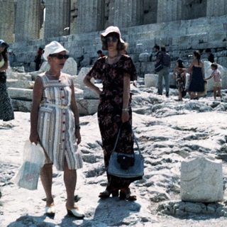 Ancient Greek temple ruins with visitors.