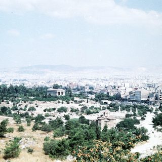 Ancient ruins overlooking modern cityscape.