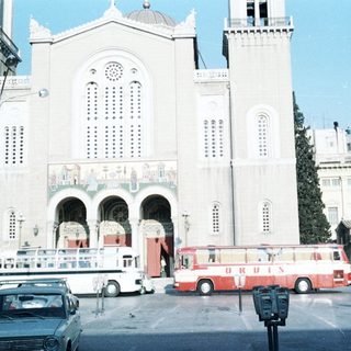 Large white church with buses in front.