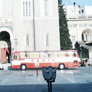 Large white church with buses in front.