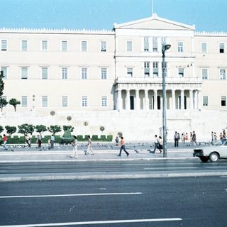 Neoclassical government building with busy street scene.