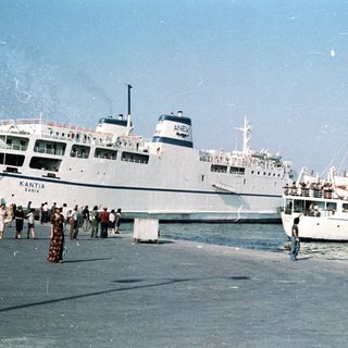 Ferry port with passengers boarding ships.