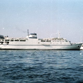 Passenger ferry vessel docked near coastal city.