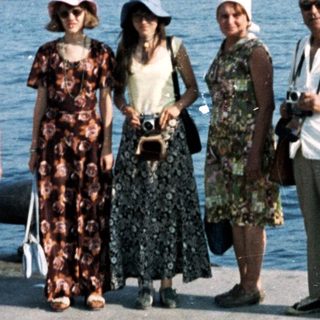 Five people posing by a waterfront city skyline.