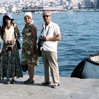 Five people posing by a waterfront city skyline.