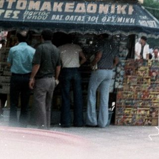 Busy urban square with street vendors and mid-20th-century buildings.